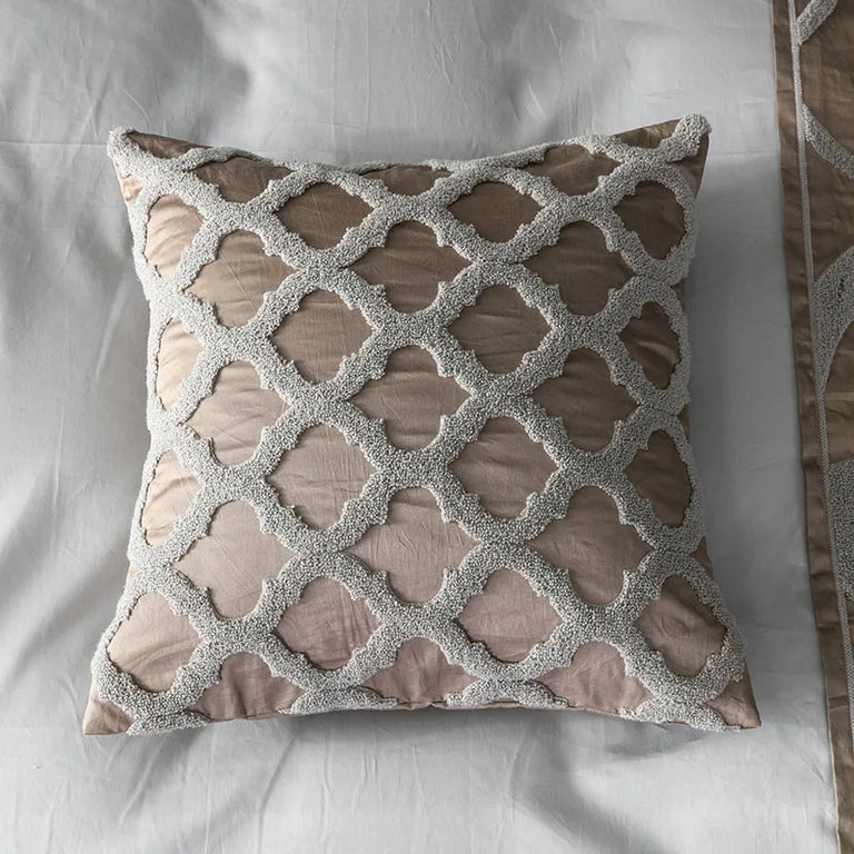 Bronze and silver embroidered pattern detail on a grey bed