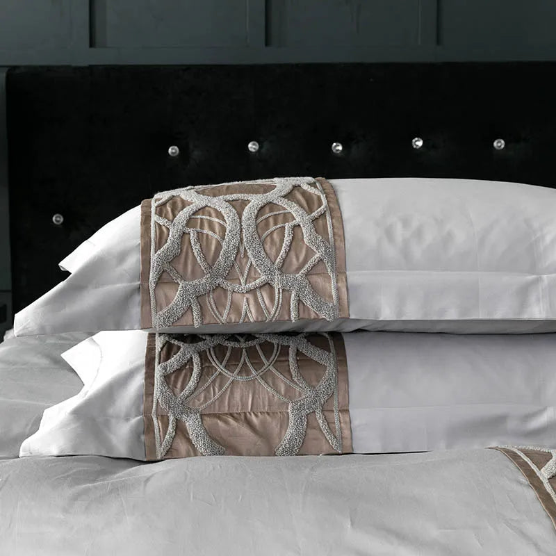 Grey pillowcases with a bronze embroidered band across the front