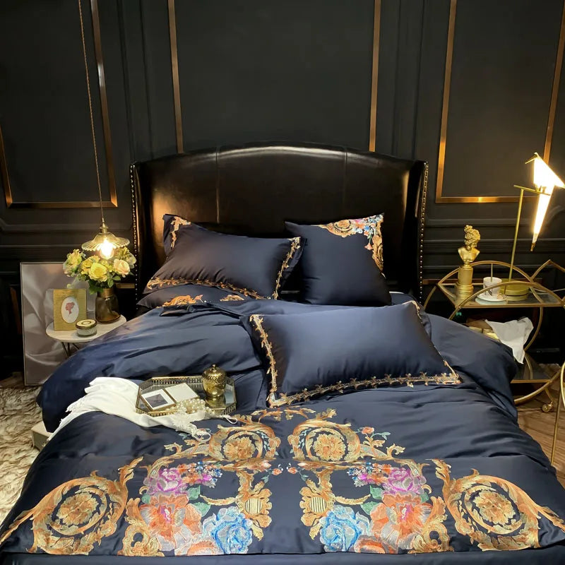 Navy pillowcases with gold trim and embroidered duvet cover on a bed