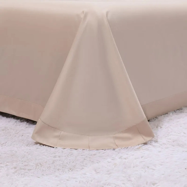 Cream sheet with a wide hem on a fluffy rug