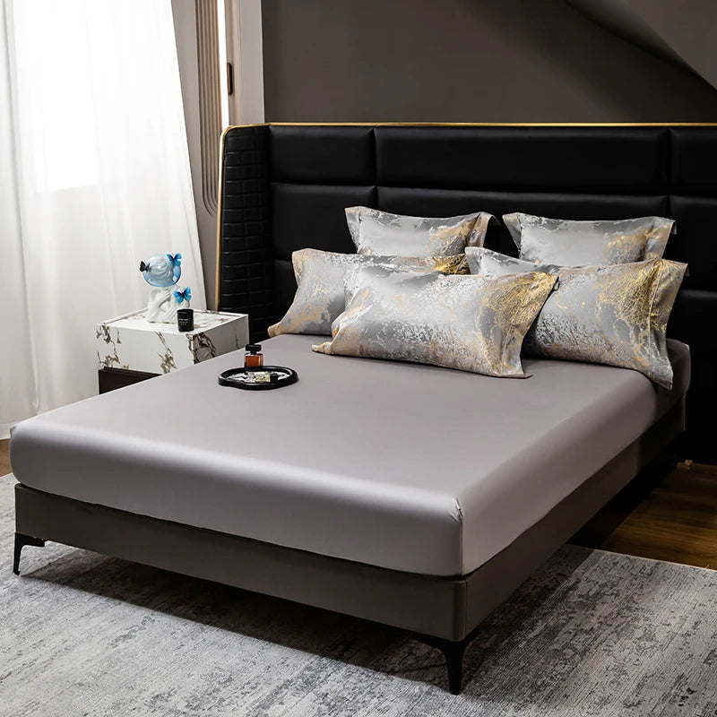 Fitted sheet with marble pattern pillowcases on a bed
