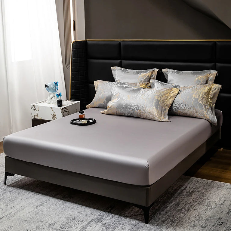 Fitted sheet with marble pattern pillowcases on a bed