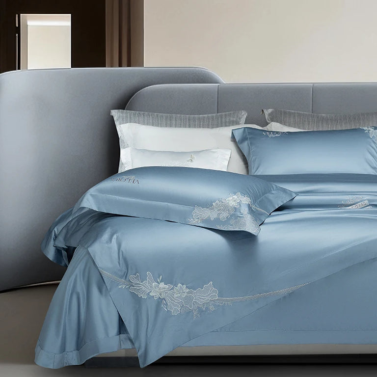 Blue bedding set with embroidered flowers along the hem