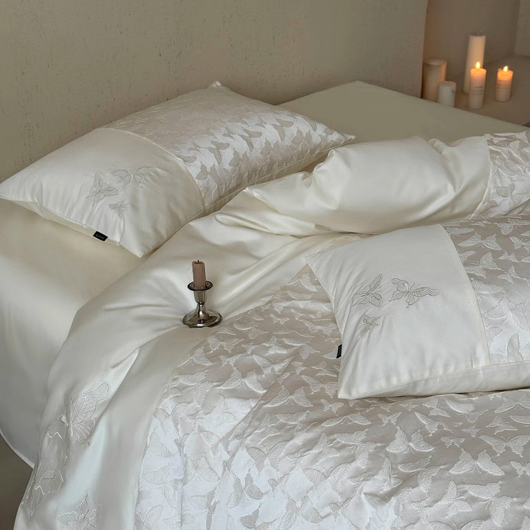 Ivory butterfly pillowcase on a bed with candles
