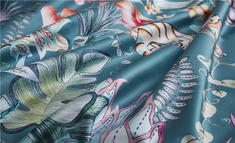 Teal tropical print fabric with leaves and pink flowers in soft folds