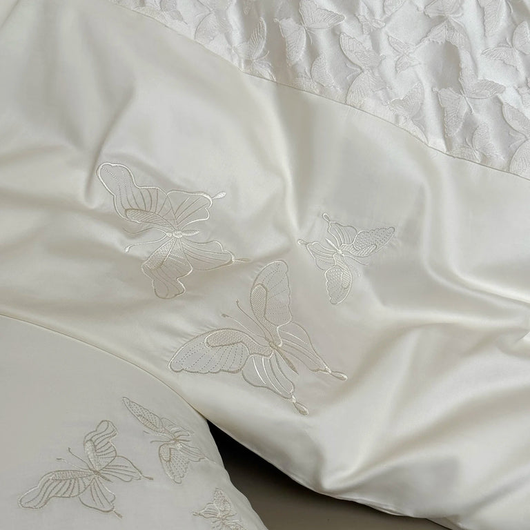 Close up of embroidered butterflies on ivory cotton