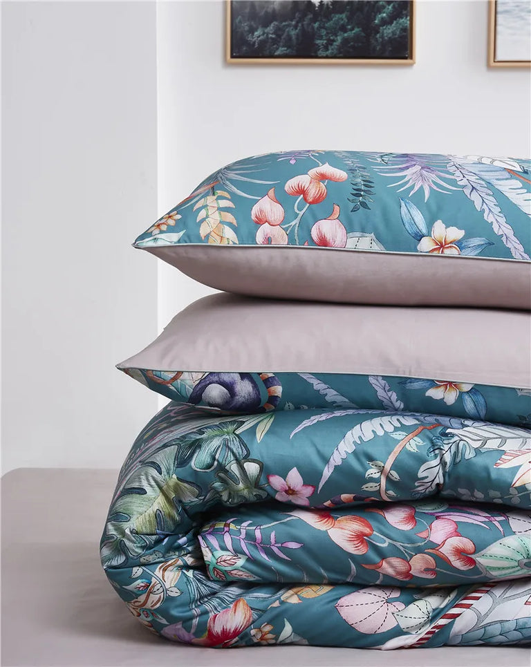 Folded teal printed duvet cover and pillowcases with blush beige reverse side
